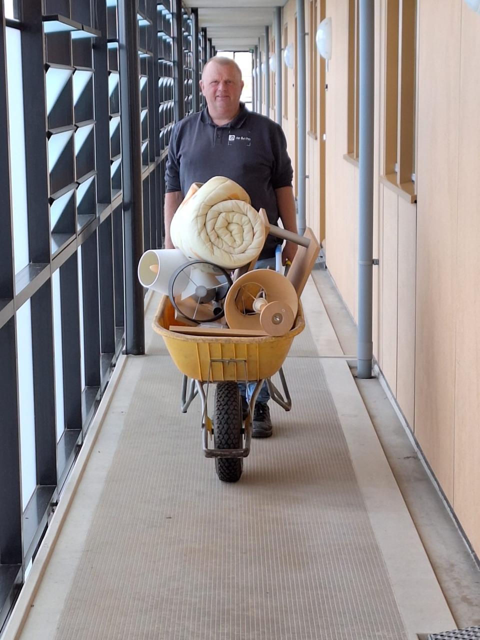 Gijs medewerker Grijs bij de Betho met kruiwagen met spullen