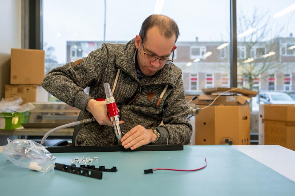 Medewerker zet iets vast met een potnageltang